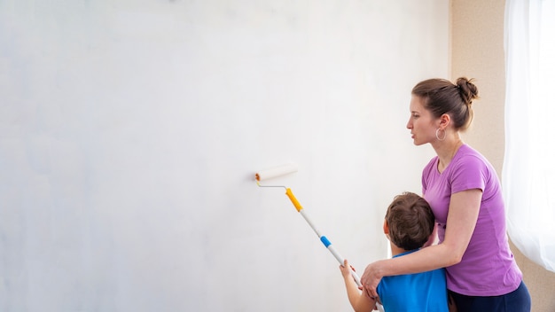 Kind mit seiner Mutter streichen die Wände