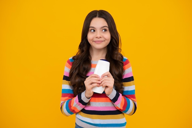 Kind mit Shampoo-Conditioner Tägliche kosmetische Pflege Teenager halten eine Flasche Haar- und Hautpflege Schönheit, Gesundheit und Kosmetik Glücklicher Teenager, positive und lächelnde Gefühle von Teenager-Mädchen
