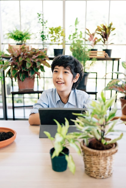 Kind mit Tablette, das während seiner Online-Lektion zu Hause über das Pflanzen lernt