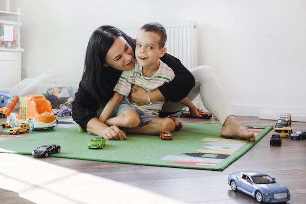 Kind mit Zerebralparese unterhält sich mit Spielzeug zur Rehabilitation zu Hause