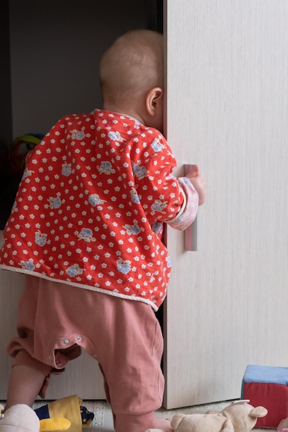 Kind öffnet einen Schrank im Wohnzimmer