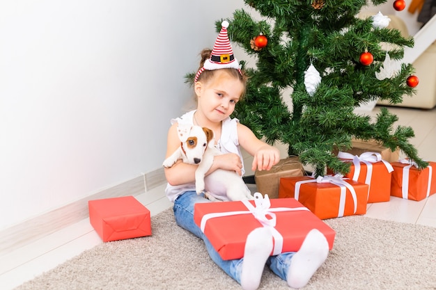 Kind öffnet Weihnachtsgeschenke. Kind unter Weihnachtsbaum mit Geschenkboxen.