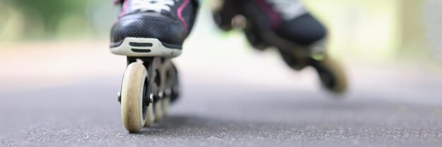 Kind reitet schwarze Rollerblades auf der Straße Nahaufnahme Kindersportkonzept