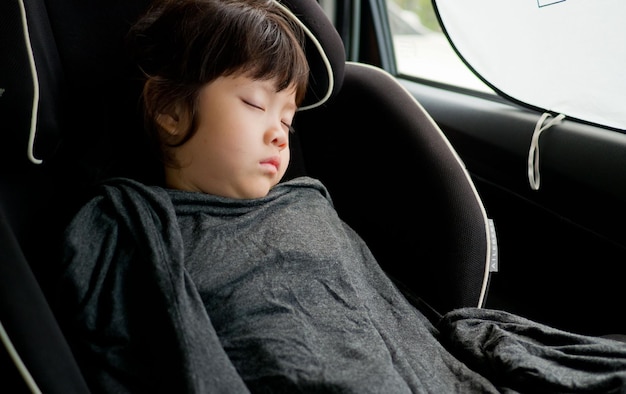 Kind schläft im Auto. Kind fühlt sich krank, schläft auf dem Autositz