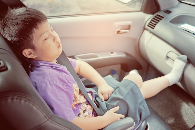 Kind schläft im Auto, Kind fühlt sich krank, schläft auf dem Autositz