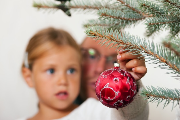 Kind schmücken den Weihnachtsbaum