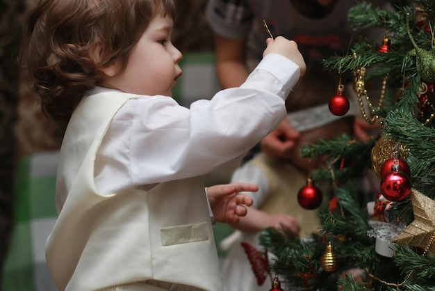 Kind schmückt das Weihnachtsbaumspielzeug