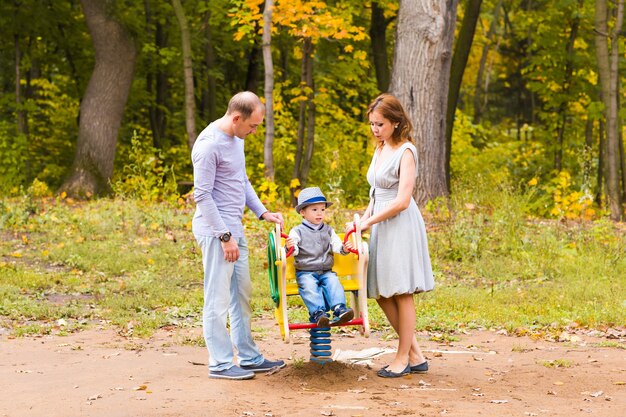 Kind spielt auf dem Spielplatz mit Mutter und Vater