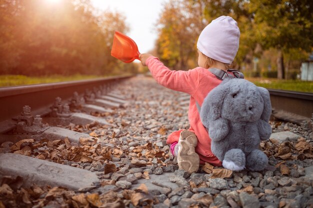 Kind spielt auf einer verlassenen Bahnstrecke und fängt an diesem Tag die letzten Sonnenstrahlen ein.