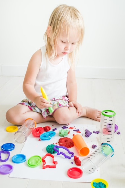 Kind spielt im Kindergarten mit buntem Plastilin