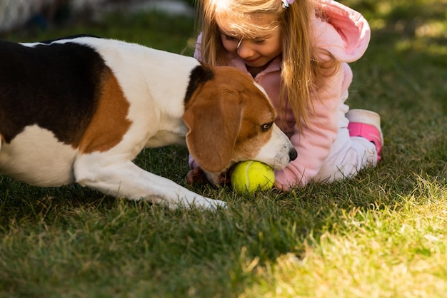 Kind spielt mit dem Hund auf dem Gras