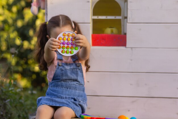 Kind spielt mit Pop itpressing die Blasen mit seiner Fingerspitze-Ansichtneues Anti-Stress-Spielzeug für Kinder...