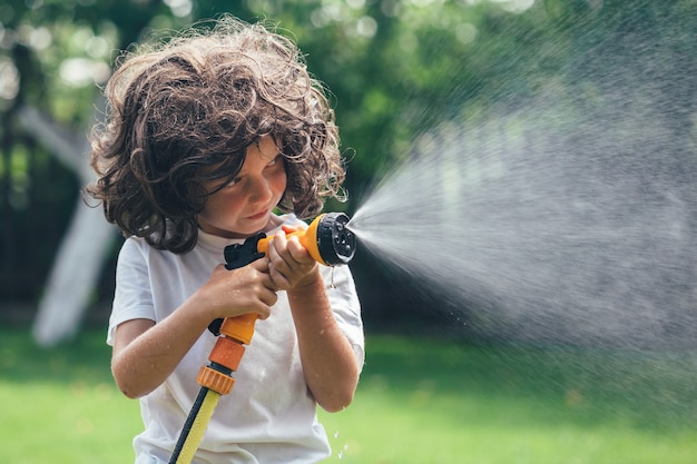 Kind spielt mit Wasser im Hinterhof im Garten