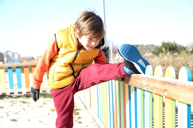 Kind streckt sein Bein auf dem Spielplatz aus