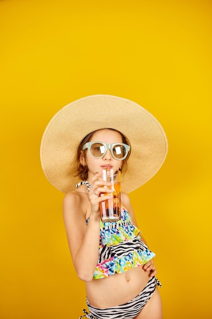 Kind Teenager Mädchen im Badeanzug Strohhut und Sonnenbrille mit Limonade