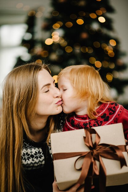 Kind überrascht seine Mutter mit einem Weihnachtsgeschenk Familie offene Geschenkbox Frohe Weihnachten