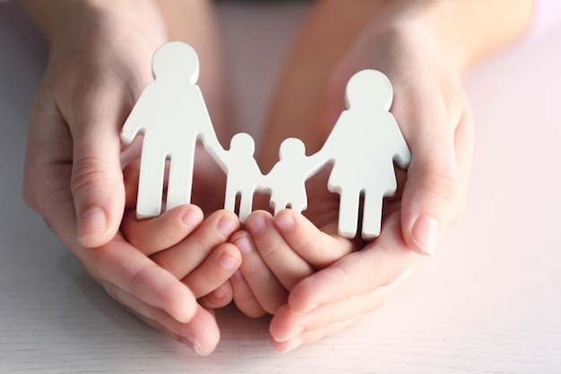 Kind und Erwachsener halten eine Figur in Form einer glücklichen Familie in der Nähe Adoptionskonzept