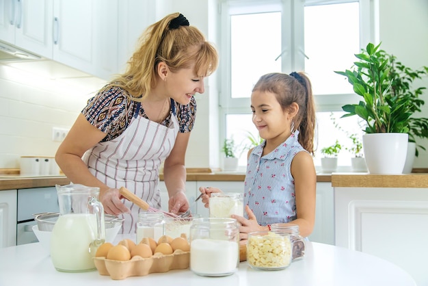 Kind und Mutter in der Küche backen bereitet den Teig in der Küche vor Selektiver Fokus Menschen