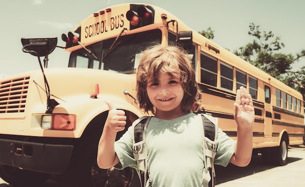 Kind von der Grundschule mit Tasche auf Schulbus backgroung glückliche Schulkinder