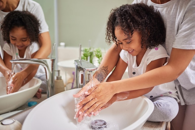 Kind wäscht Hände und Familie spült Reinigung und gute Hygiene gegen Bakterien oder Keime für Infektions- oder Virenschutz im Badezimmer Mädchen mit Mutter für Gesundheit und Sauberkeit