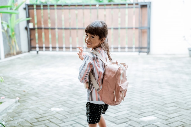 Kind winkt zum Abschied, bevor es zur Schule geht