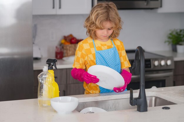 Kind wischt Geschirr in der Küche ab Kind putzt und macht Hausarbeit zu Hause süßer Junge hilft beim Haushalt