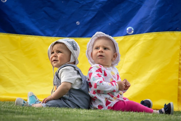 Kinder auf dem Hintergrund der Flagge der Ukraine Kleine Jungen und Mädchen Babys hautnah