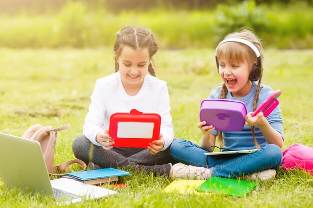 Kinder auf dem Picknick im Schulgrashof kommen, essen in der Box zu Mittag. Eltern kümmern sich um die Kinderbetreuung.