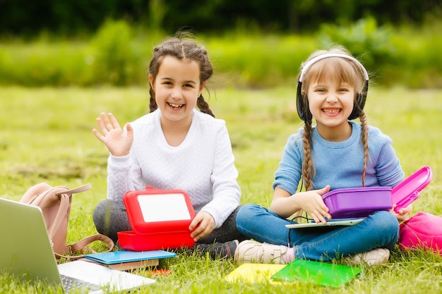 Kinder auf dem Picknick im Schulgrashof kommen, essen in der Box zu Mittag. Eltern kümmern sich um die Kinderbetreuung.