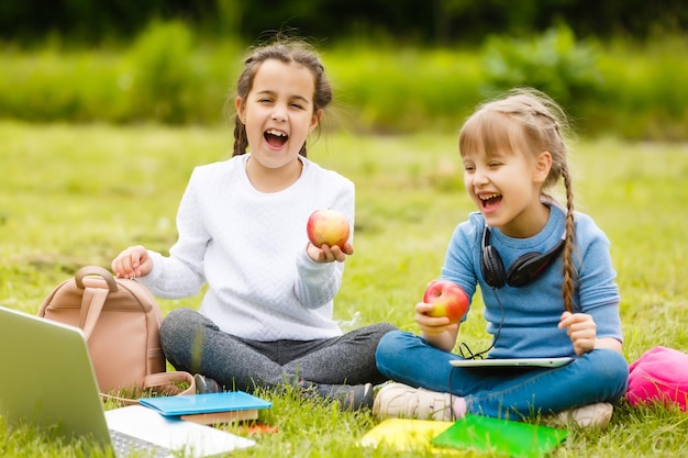 Kinder auf dem Picknick im Schulgrashof kommen, essen in der Box zu Mittag. Eltern kümmern sich um die Kinderbetreuung.