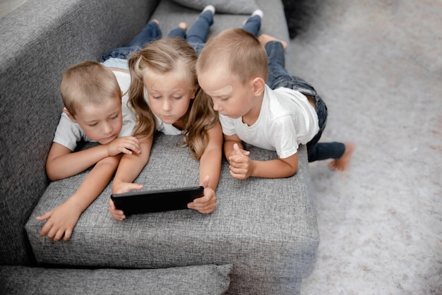 Kinder auf einem Sofa mit einer Tablette