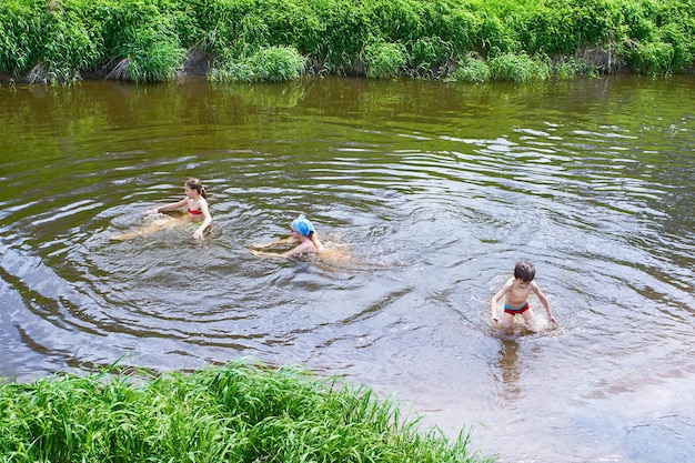 Kinder baden im Sommertag im Fluss