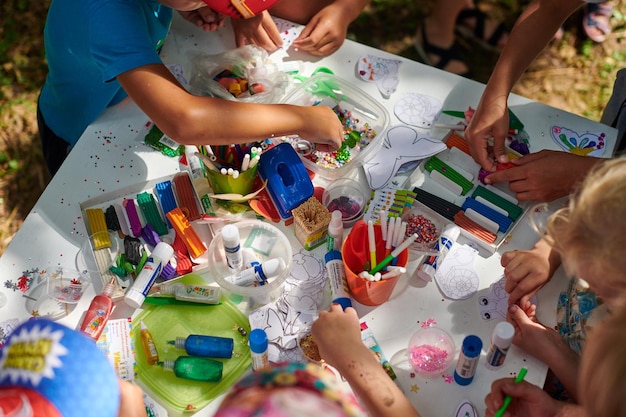 Kinder basteln mit den Eltern auf einer Kinderparty im Freien und malen Formen aus Plastilin