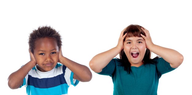 Kinder bedecken die Ohren und sind schockiert von einem lauten Geräusch