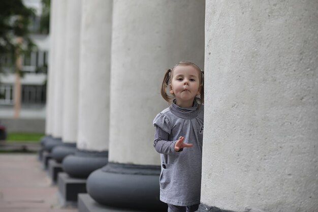 Kinder bei einem Spaziergang im Frühling im Stadtpark. Das Mädchen geht im Park spazieren. Kinder und Mama laufen durch die Stadt.