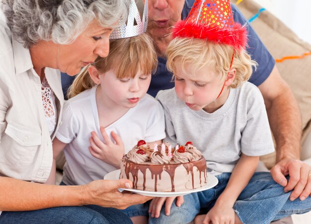 Kinder blasen auf den Geburtstagskuchen