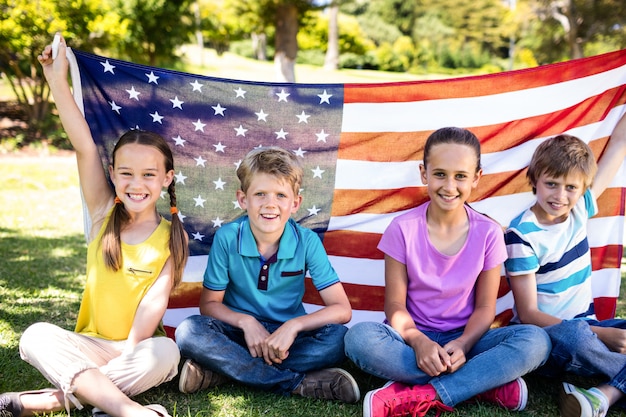 Kinder, die amerikanische Flagge im Park halten