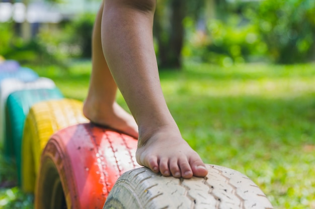 Kinder, die auf Reifen auf dem Spielplatz laufen