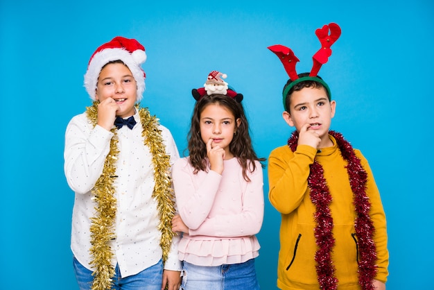 Kinder, die den Weihnachtstag tut Ausdrücke feiern