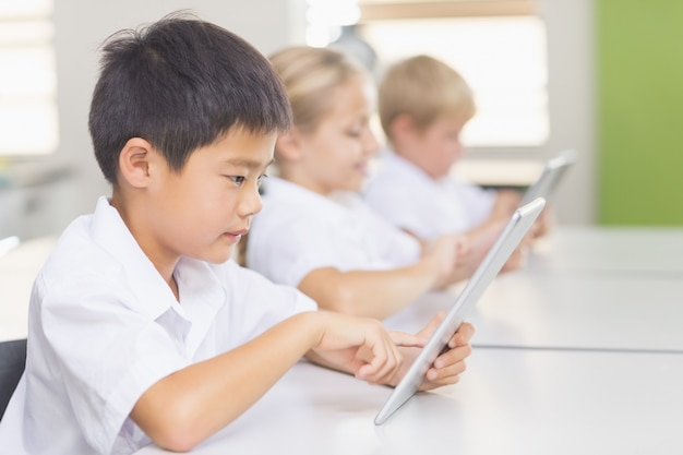 Kinder, die digitales Tablet im Klassenzimmer verwenden