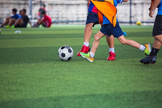 Kinder, die Fußballtaktiken auf dem Rasen spielen, mit für den Trainingshintergrund Training von Kindern im Fußball