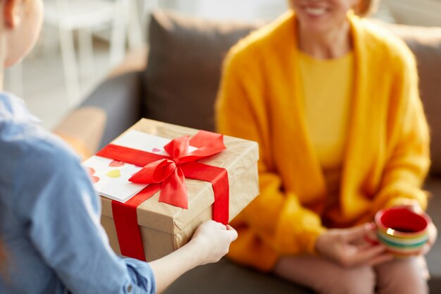 Kinder, die geschenk für mama präsentieren