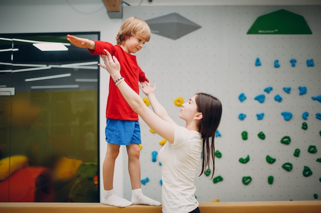 Kinder, die im Kindergarten oder in der Grundschule Schwebebalken-Gymnastikübungen im Fitnessstudio machen. Kindersport- und Fitnesskonzept.