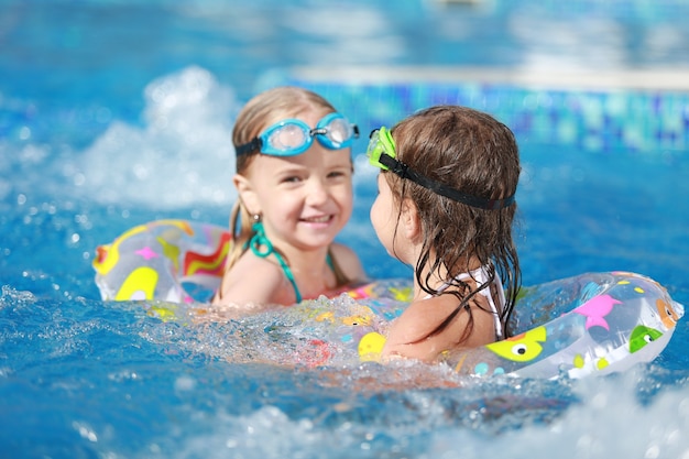 Kinder, die im Pool spielen. Zwei kleine Mädchen, die Spaß im Pool haben.