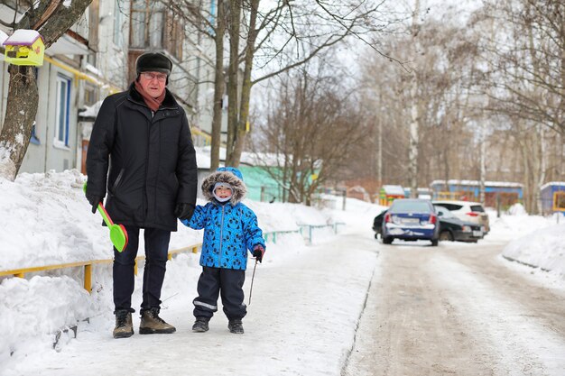 Kinder, die im Winter im Hinterhof in der Stadt mit Schnee spielen