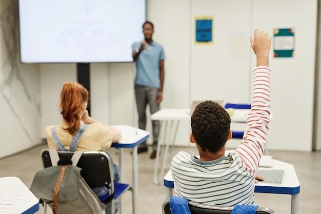 Kinder, die in der Klasse die Hände heben