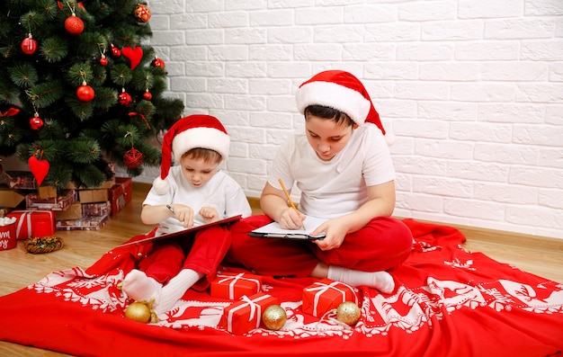 Kinder, die in der Nähe der Weihnachtsbaumfamilie mit Geschenken am Weihnachtsabend spielen