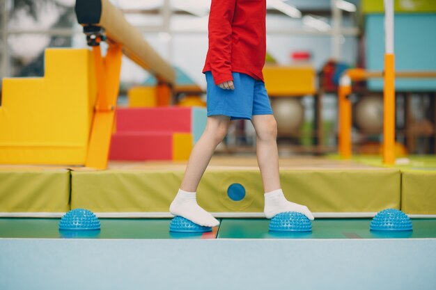 Kinder, die Massage-Igel für Fußbeinübungen im Fitnessstudio im Kindergarten oder in der Grundschule machen. Kindersport- und Fitnesskonzept.