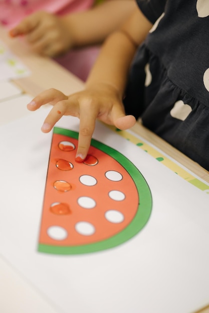 Kinder, die mit den Fingern im Kindergarten malen, glückliche Kinder, mittlere Auswahl