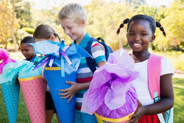 Kinder, die mit ihrer Geschenküberraschung während eines sonnigen Tages aufwerfen